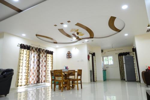 a dining room with a table and chairs and a ceiling at Agastya FarmsPoolAC4BHKParty Villa25 PaxWifi in Hyderabad
