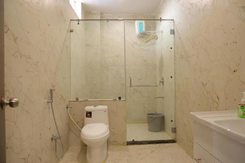 a bathroom with a shower with a toilet and a sink at Agastya FarmsPoolAC4BHKParty Villa25 PaxWifi in Hyderabad