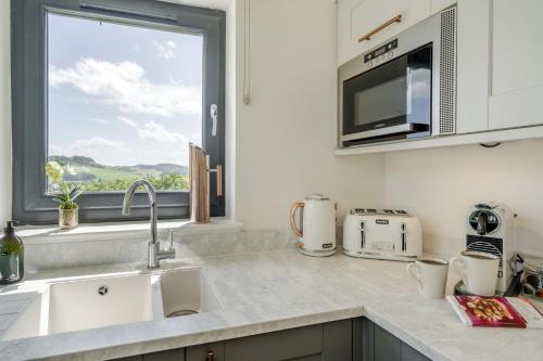 a kitchen with a sink and a microwave and a window at 2 Bed in Newburgh oc-g32594 in Newburgh