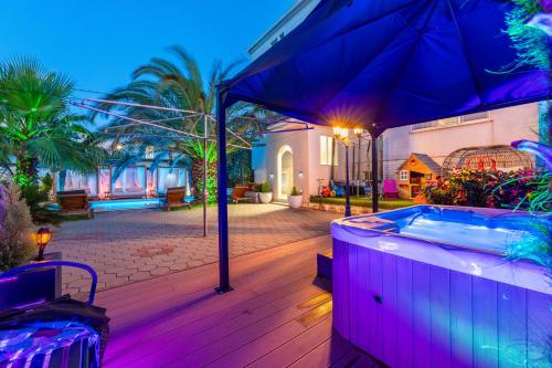 a jacuzzi tub on a deck in a house at Apartments Bracic Spa in Sukošan