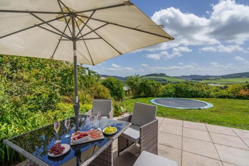 a table with an umbrella and food on a patio at 2 Bed in Newburgh oc-g32594 in Newburgh