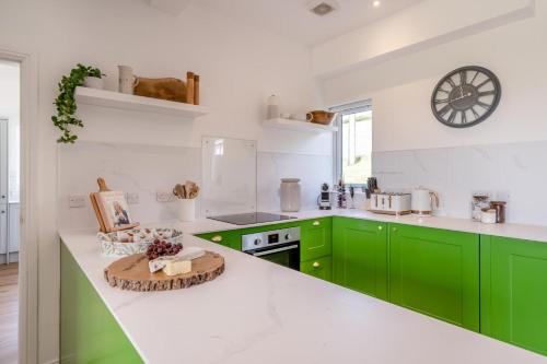 a kitchen with green cabinets and a clock on the wall at 2 Bed in Newburgh oc-f32595 in Newburgh