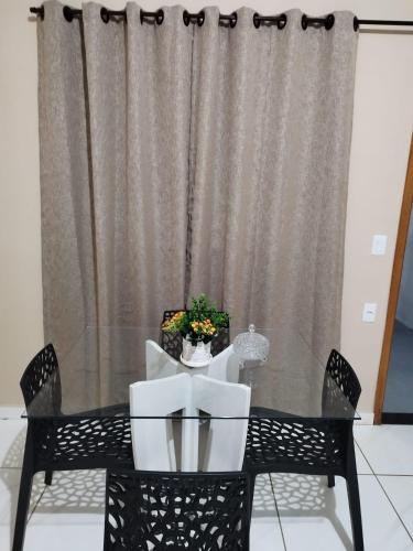 a dining room table and chairs with a curtain at Casa Prizon in Olímpia