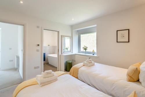 two beds in a room with a tub and a window at 2 Bed in Newburgh oc-f32595 in Newburgh