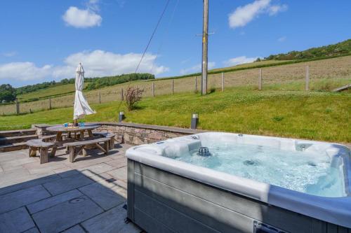 a hot tub on a patio with a picnic table at 2 Bed in Newburgh oc-f32595 in Newburgh