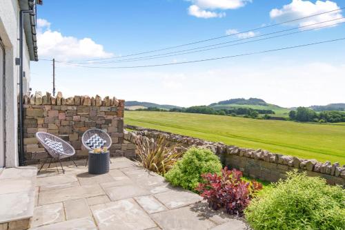a patio with a stone wall and a bench at 2 Bed in Newburgh oc-f32595 in Newburgh