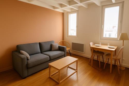 un salon avec un canapé et une table dans l'établissement Home Sweet Home Champs Elysées Niel, à Paris