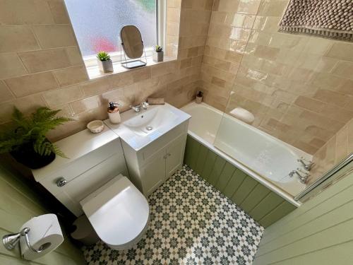 ein Badezimmer mit Toilette, Waschbecken und Badewanne in der Unterkunft Cosy cottage near Saltburn & Whitby in Boosbeck