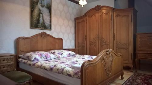 a bedroom with a bed and a wooden cabinet at Noclegi Dwór Szlachecki Biedaczów in Biedaczów