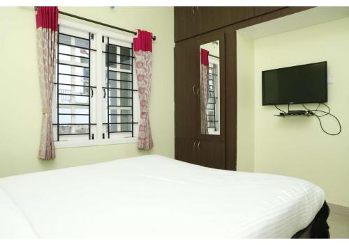 a bedroom with a bed and a flat screen tv at Cozy Heaven in Ooty