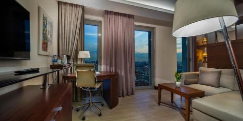 a living room with a desk and a couch at Doubletree By Hilton Istanbul Topkapi in Istanbul