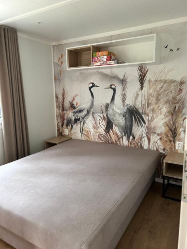 ジブヌフにあるRogaty Domek nad Bałtykiemのベッドルーム1室(鳥の壁画付)