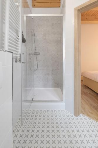 a shower with a glass door in a bathroom at Apartmány LehotSKI Guest House in Pavčina Lehota