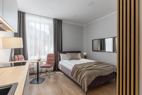 a bedroom with a bed and a desk and a window at P6-A Riga Old Town Apartments in Rīga