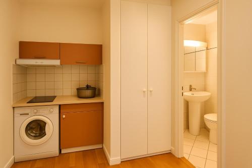 une cuisine avec lave-linge dans la salle de bains dans l'établissement Home Sweet Home Champs Elysées Niel, à Paris
