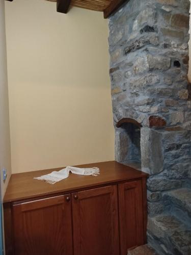 a room with a stone wall with a wooden cabinet and a stone counter at Volissos Sea View Maisonettes in Volissos