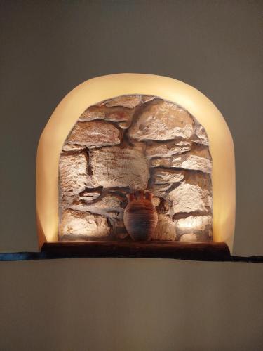 a stone wall with a vase sitting on a shelf at Volissos Sea View Maisonettes in Volissos