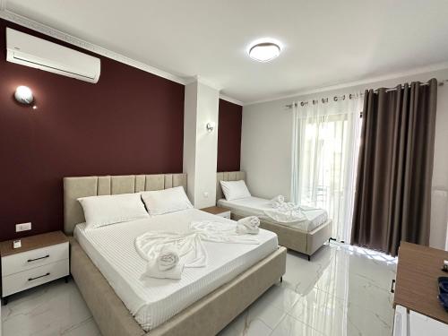 a bedroom with two beds and a window at LiEl Holiday in Vlorë