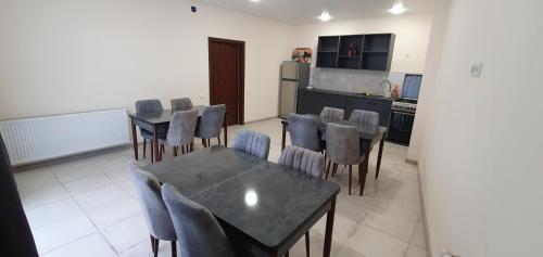 a dining room with a table and chairs and a kitchen at Elnetsa Inn Kazbegi in Stepantsminda