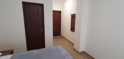 a bedroom with a door and a bed in a room at Elnetsa Inn Kazbegi in Stepantsminda
