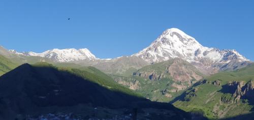 a view of a mountain range with a city at Elnetsa Inn Kazbegi in Stepantsminda