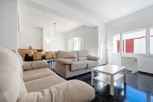 a living room with a couch and a table at Hauzify I Apartament Riera in Platja  d'Aro
