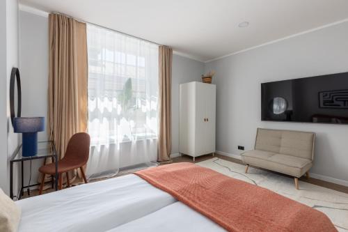 a bedroom with a bed and a chair and a window at P6-A Riga Old Town Apartments in Rīga