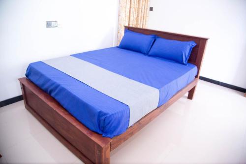 a bed with blue sheets and blue pillows in a room at Gin Green Villa in Galle