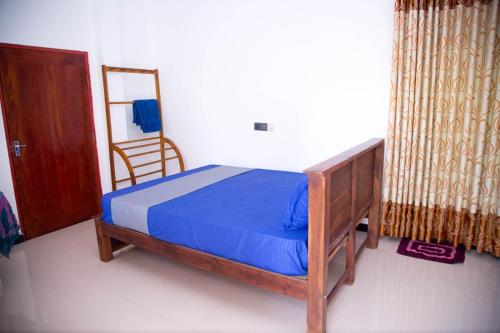 a bedroom with a bed with blue sheets and a mirror at Gin Green Villa in Galle