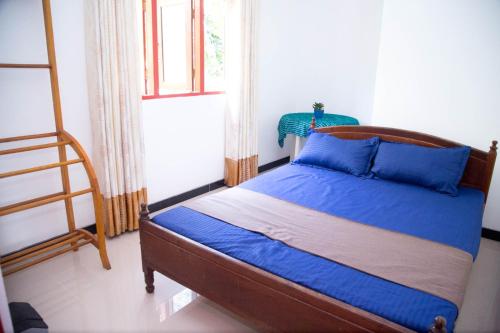 a bedroom with a bed with blue sheets and a ladder at Gin Green Villa in Galle