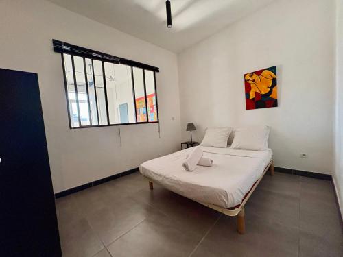 a white room with a bed and a window at L'Appartement sur quai - en face de la Criée in Sète