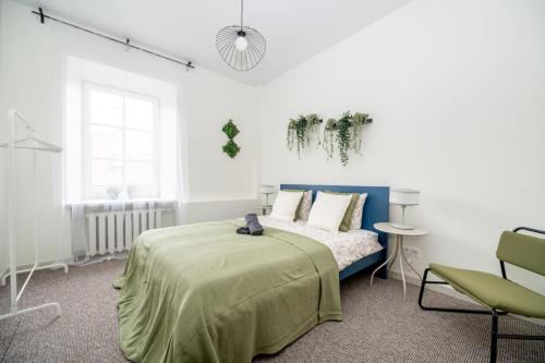 a white room with a bed and a chair at City Nest Vilnius Oldtown in Vilnius