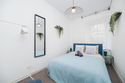 a bedroom with a blue bed and a mirror at City Nest Vilnius Oldtown in Vilnius