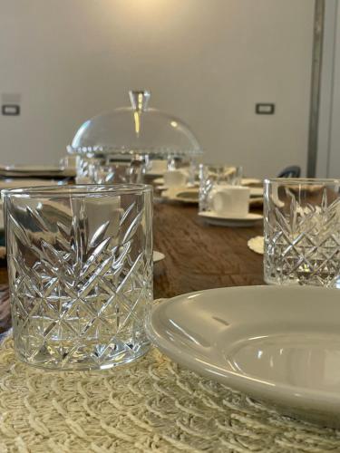a table with glasses and plates on a table at Titanya - Bed And Breakfast Di Galatea Casa Vacanze in Corsano