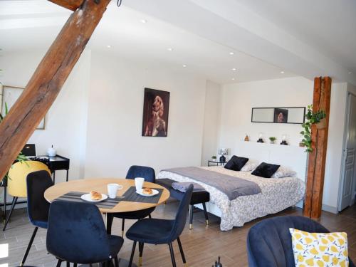 a bedroom with a bed and a table and chairs at La Demeure de Beauvoir - Confort & authenticité in Blois