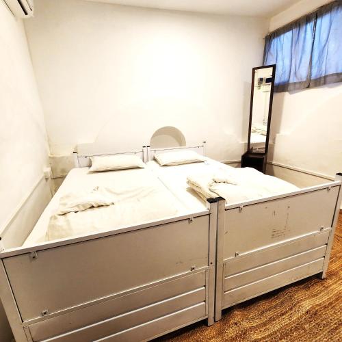 a white bed in a room with a mirror at Hammock Hostels - Bandra in Mumbai