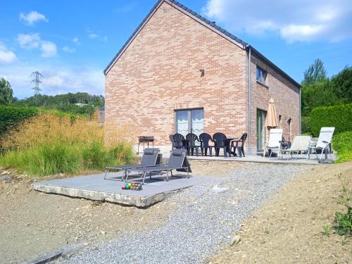 a brick house with chairs and a table at Au coin de détente in Durbuy