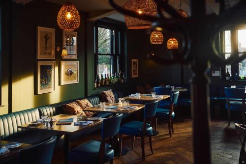 a restaurant with tables and chairs in a room at The White Hart Inn in West Mersea