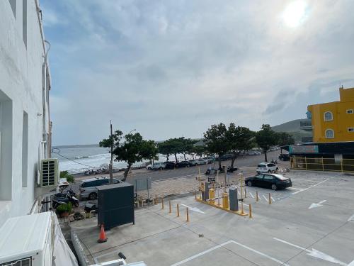 a parking lot next to the ocean with cars parked at QBE 民宿 南灣館 QBE Nanwan in Nanwan