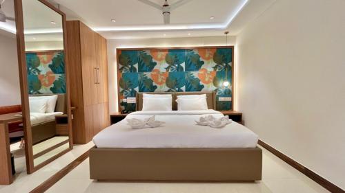 a bedroom with a bed and a large painting on the wall at Hotel Pearl Palace in Cochin
