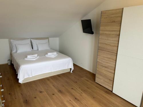 a bedroom with a bed with white sheets and a mirror at Villa Panorama in Senj