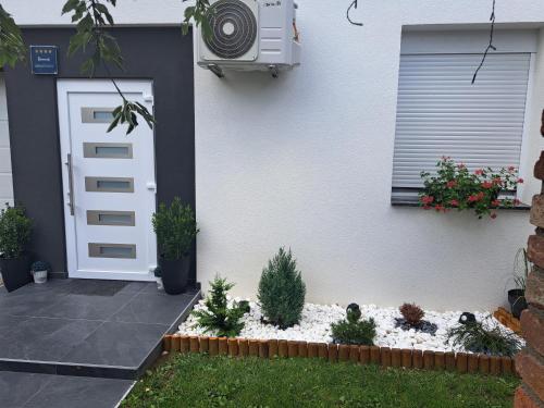 a front door of a house with a garden with plants at Apartman Pariz in Slavonski Brod