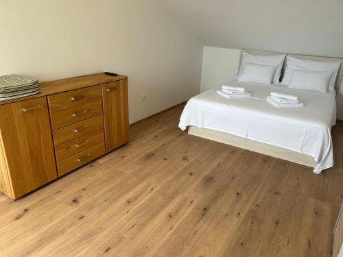 a bedroom with a white bed and a wooden dresser at Villa Panorama in Senj