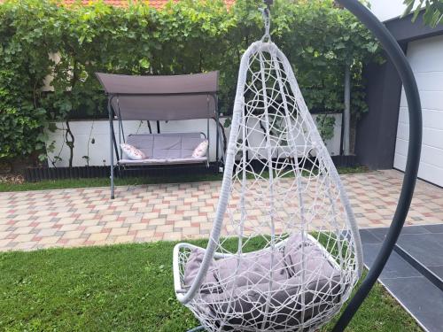 a white rope swing with a chair in a yard at Apartman Pariz in Slavonski Brod