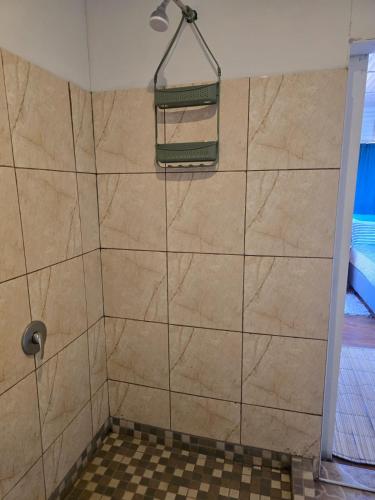 a bathroom with a shower with a tiled floor at Sunrise Beach Lodge in Ponta Malongane