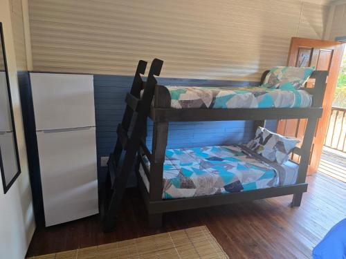 two bunk beds in a room with a refrigerator at Sunrise Beach Lodge in Ponta Malongane