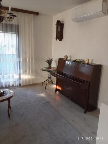 a living room with a piano and a table at Hiža Guesthouse in Sarajevo