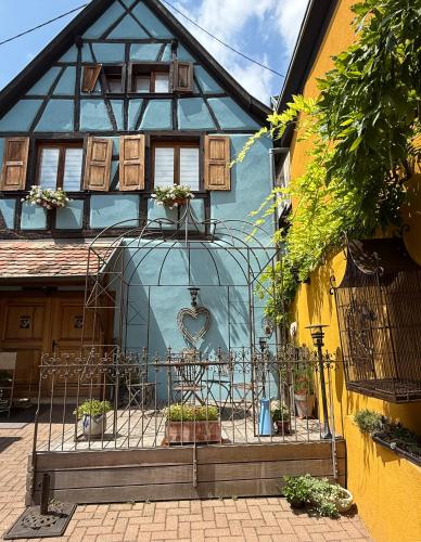 a house with a gate in front of it at Gîte Aux P'tits Cœurs d'Alsace in Beblenheim