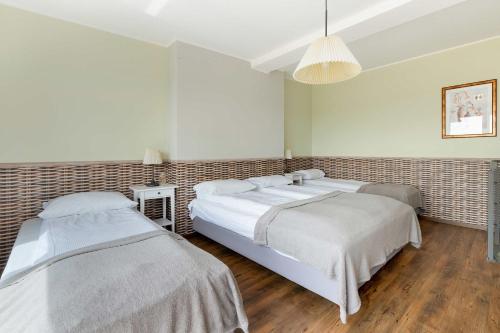 a bedroom with two beds and a chandelier at Family Apartment Puck Closeto the Sea by Noclegi Renters in Puck