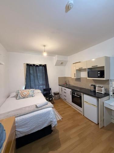a bedroom with a large bed and a kitchen at Beautiful apartment close to central London in London